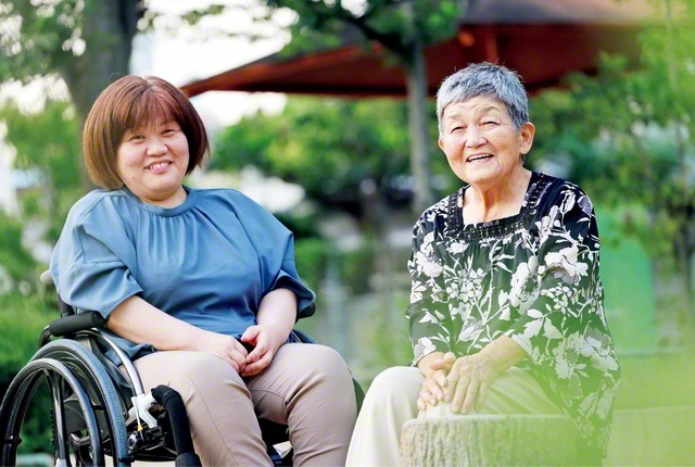 黒河さん㊧が母・富貴子さん（地区副女性部長）と共に。白ゆり長として、ブロック内の一人一人のために手紙を添えて訪問激励に歩む黒河さん。その傍らにはいつも、母の姿が。「二人で一人前やな」と語らう母娘の笑顔があふれる