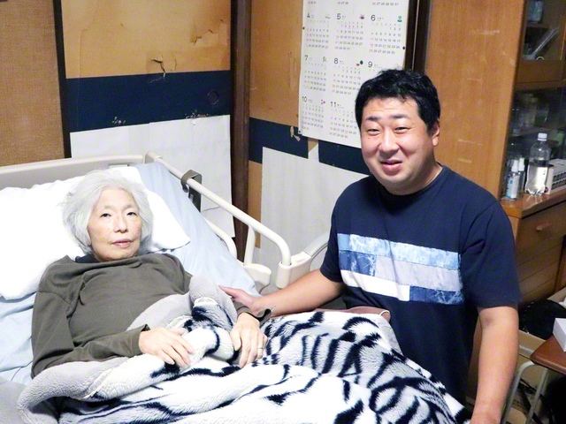 根本さん㊨は、感謝の思いで、母・八重子さんの介護に尽くす
