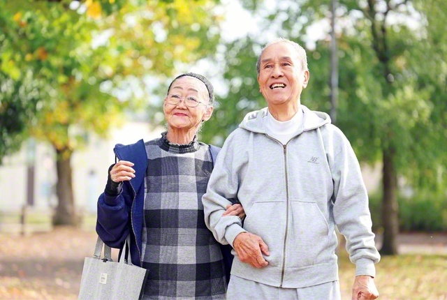 夫・忠司さん㊨（副誓願長〈副ブロック長〉）と笑顔で過ごす忠藤さん。“地域のために”と保健委員や老人会の役員も積極的に務めてきた。今は長年タクシーの運転手として働いてきた忠司さんの運転で共に、“広布の活動に出かけるのが楽しみ”と日々を送る