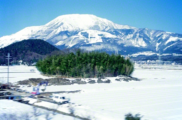 池田先生が、関西から中部へ向かう新幹線の車中から撮影しました（2000年3月）。窓の外には雪景色が広がり、遠くの伊吹山もふんわりと白い衣をまとっています。先生は、雪の降るある日に、“雪のような純真な信心をしていけば、何ものにも染められることのない自分自身を築き上げていける”と語りました