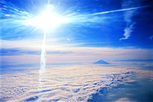 まぶしくかがやく太陽の光が、海のように広がる雲と、そこから頭を出す富士山を照らしています。2000年11月、池田先生が東京から福岡に向かう飛行機の中からさつえいしました。先生は未来部のメンバーに「（どんな困難も）負けじ魂で挑み続けていく中で、悩みの雲は必ず吹き払っていける」とエールを送りました