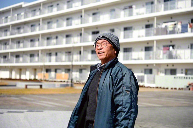 時折冷たい風が吹く中、災害公営住宅での暮らしを語る西條さん。震災当時に届いた支援物資の帽子を愛用している