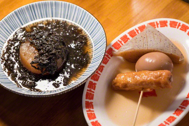 だしの染みた大根に岩のりをたっぷりと乗せた岩のり大根（469円）㊧。△○□の形の、こんにゃく、玉子、ごぼ天のおでんを串に刺した、ザ・おでん串（539円）