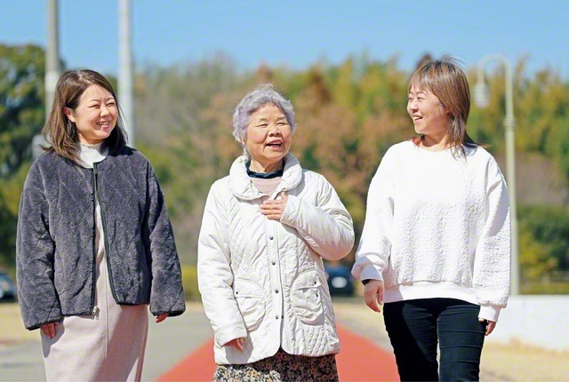 宮本さん㊥の心に残っているのは、1994年に福岡ドーム（当時）で行われた“5万人の第九”。池田先生の席のすぐ近くに座ることができ、師匠が写真を撮影するなどして友を励ます姿に感動し、心が震えた。昨年、同じ場所で開かれた“世界平和の第九”に長女・大川直子さん㊧（支部女性部長）、次女・光永法子さん㊨（地区女性部長）が参加。また、宮本さんの孫が創価大学を卒業したことも誇りと目を細めた