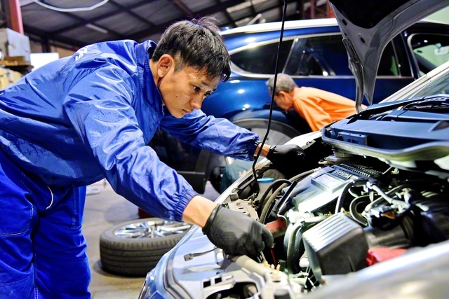 エンジンの点検作業を行う中村さん。細かな部品の状態を一つ一つ確認していく（父の自動車整備工場で）