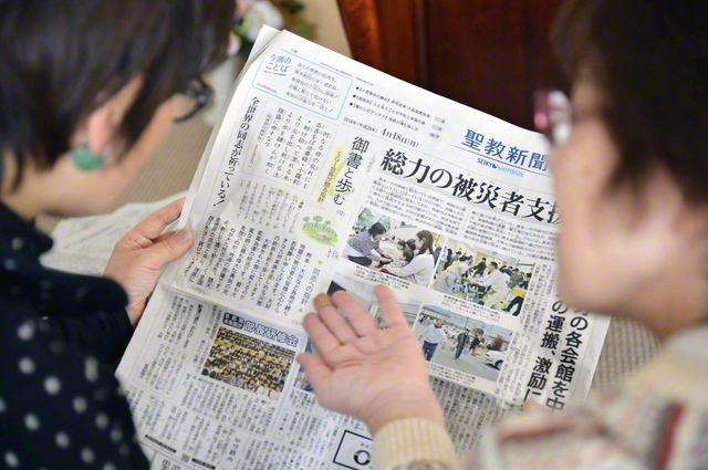 友が池田先生の励ましが掲載された聖教新聞を手に（2016年4月19日、阿蘇市で）