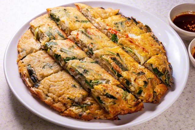 海鮮ネギチヂミ〈大〉（3828円）。ふわっとした分厚い生地にはえび、いか、たこなどがどっさり。直径約30センチ程の（大）は約5人前