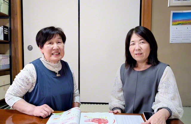 高橋さん㊧は船橋地区女性部長と朗らかに前進する