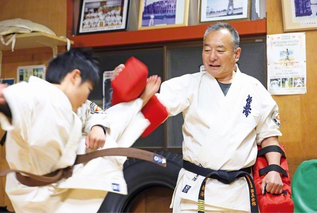 子どもたちに空手の稽古をつける入澤さん。息子たちが小学生のころはPTAの役員も務めた。現在は職業訓練指導員としても活躍。「今、こうして元気に動けているのも、妻（広子さん＝女性部員）の支えのおかげです」と感謝を語る