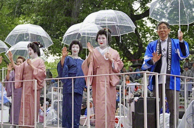 「ジャパン・パレード」で、沿道の観客に手を振る長崎検番の芸妓衆と伊達良弘・長崎県文化観光国際部長（右端）＝9日、米ニューヨーク・マンハッタン（共同）