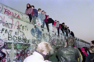 1989年11月、東西冷戦を象徴するベルリンの壁が崩壊した。若者たちが壁によじ登って喜ぶ（共同）