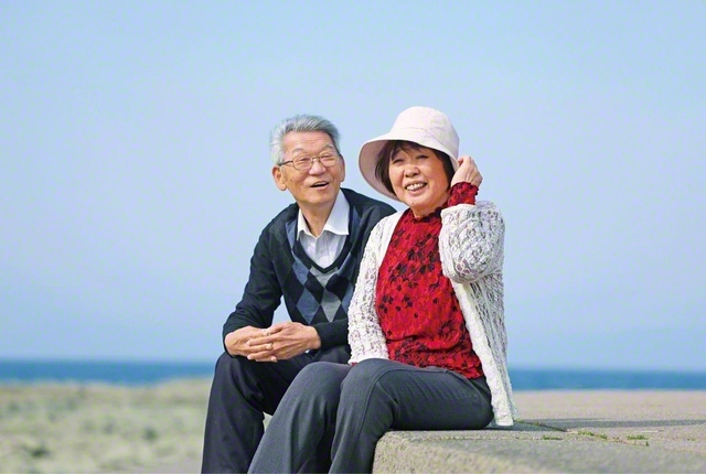 村上さん㊨と夫・由文さん（副圏長）が笑顔で。夫の両親は、草創から地域の一粒種として広布に歩んできた。その信心を継承し、由文さんも先生との数々の原点を築いてきた。「師匠への感謝を忘れず、日々祈り抜いていくことを夫婦で誓い合っています」と