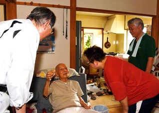 鷹尾総県総合長（左端）らが吉村利宣さん（左から2人目）に発災当時の状況を聞く（7月29日、熊本市南区で）