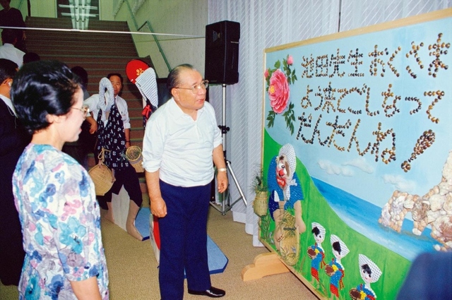 7年ぶりに島根を訪問した池田先生。会館のロビーで友が制作したパネルを鑑賞した（「だんだん」は出雲・伯耆地方の方言で「ありがとう」の意）。“どじょうすくい”を愉快に生き生きと描いた飾り絵に対し、先生はこの日の夜、制作に携わった友へ「ありがとう」と真心の伝言を贈った（1991年9月9日、安来会館）
