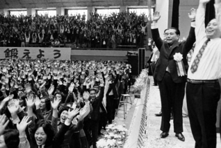 10・13「山梨の日」の淵源となった「山梨広布20年記念総会」で、参加者と万歳をする池田大作先生（1974年10月13日、甲府市内で）