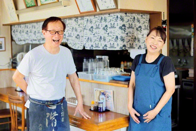 「店には聖教新聞を置いています。『いいこと書いてあるよね』と、お客さんにも好評です」と関本さん㊧。共に店を切り盛りする妻・忍さんとの呼吸もピッタリ。2人の子どもも信心根本に使命の道を進む