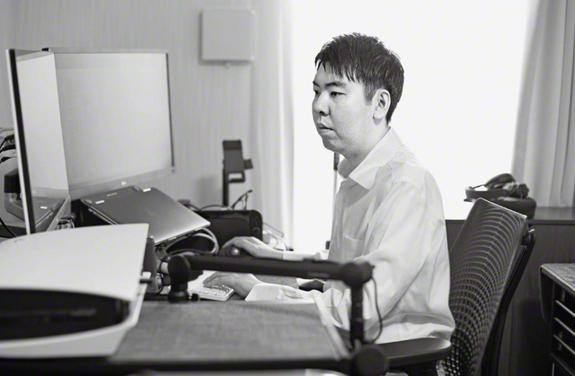 AIエンジニアとして活躍する倉橋さんの原動力は、「法華経の行者」としての広布誓願の祈りと学会活動。病気の進行で車椅子生活になり自由に動くことは難しくなったが、共に活動する男子部リーダーの車に乗せてもらい、家庭訪問にも率先して励んでいる