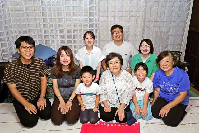 佐藤さん（前列左端）、妻・遥さん（前列左から2人目）と青ケ島の同志が、築100年以上の広布の会場で